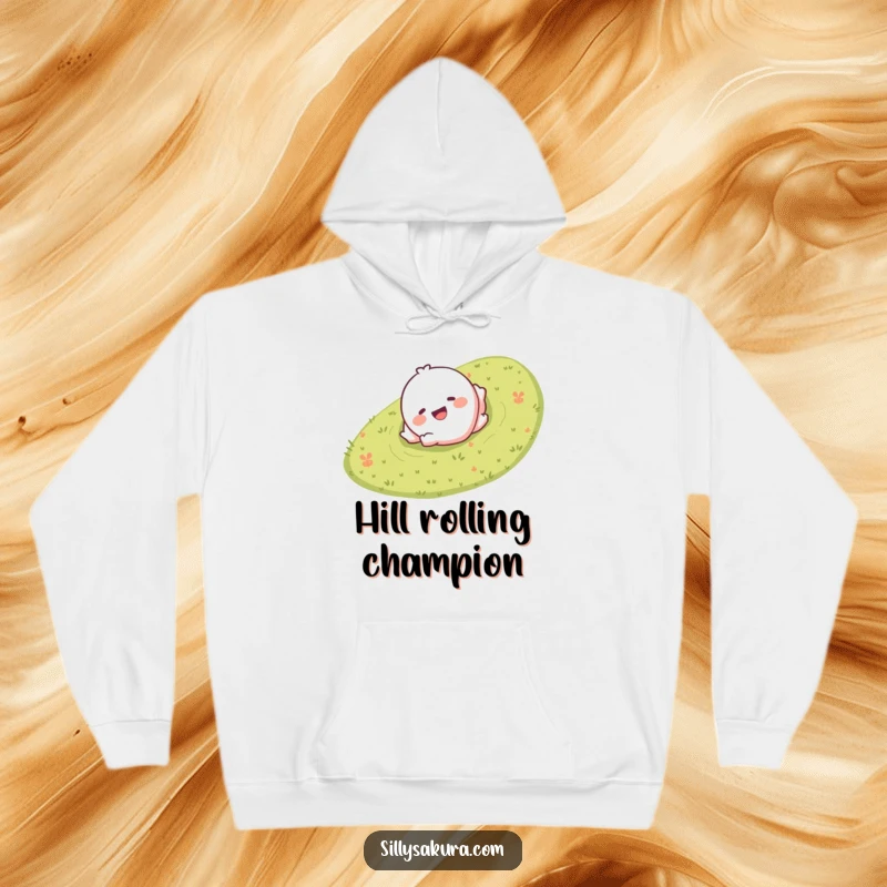 Funny hoodie with a giggling character smiling and rolling down a grassy hill, offering cozy and joyful vibes.
